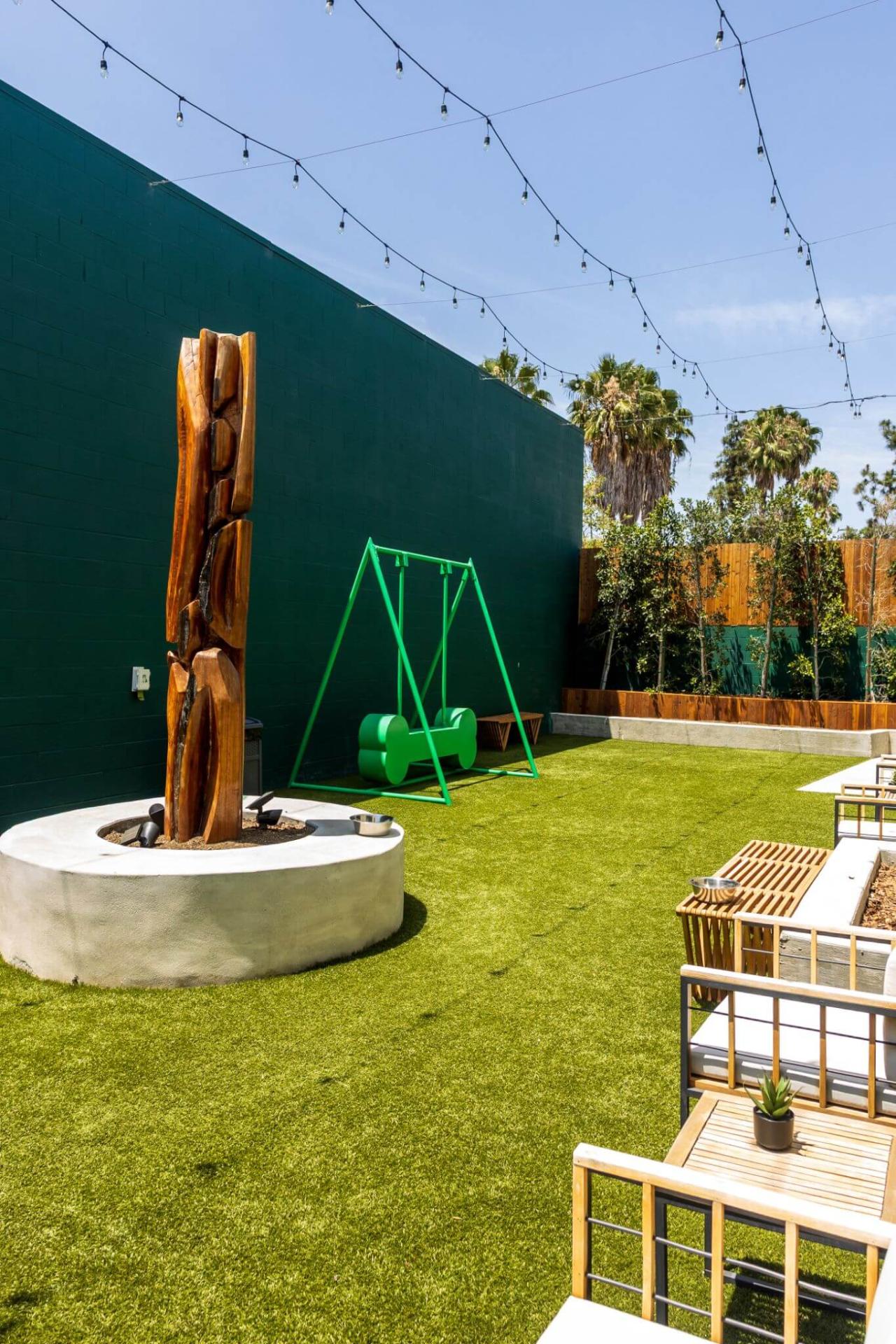 Turf play yard with a swing set and shaded seating in Van Nuys, CA