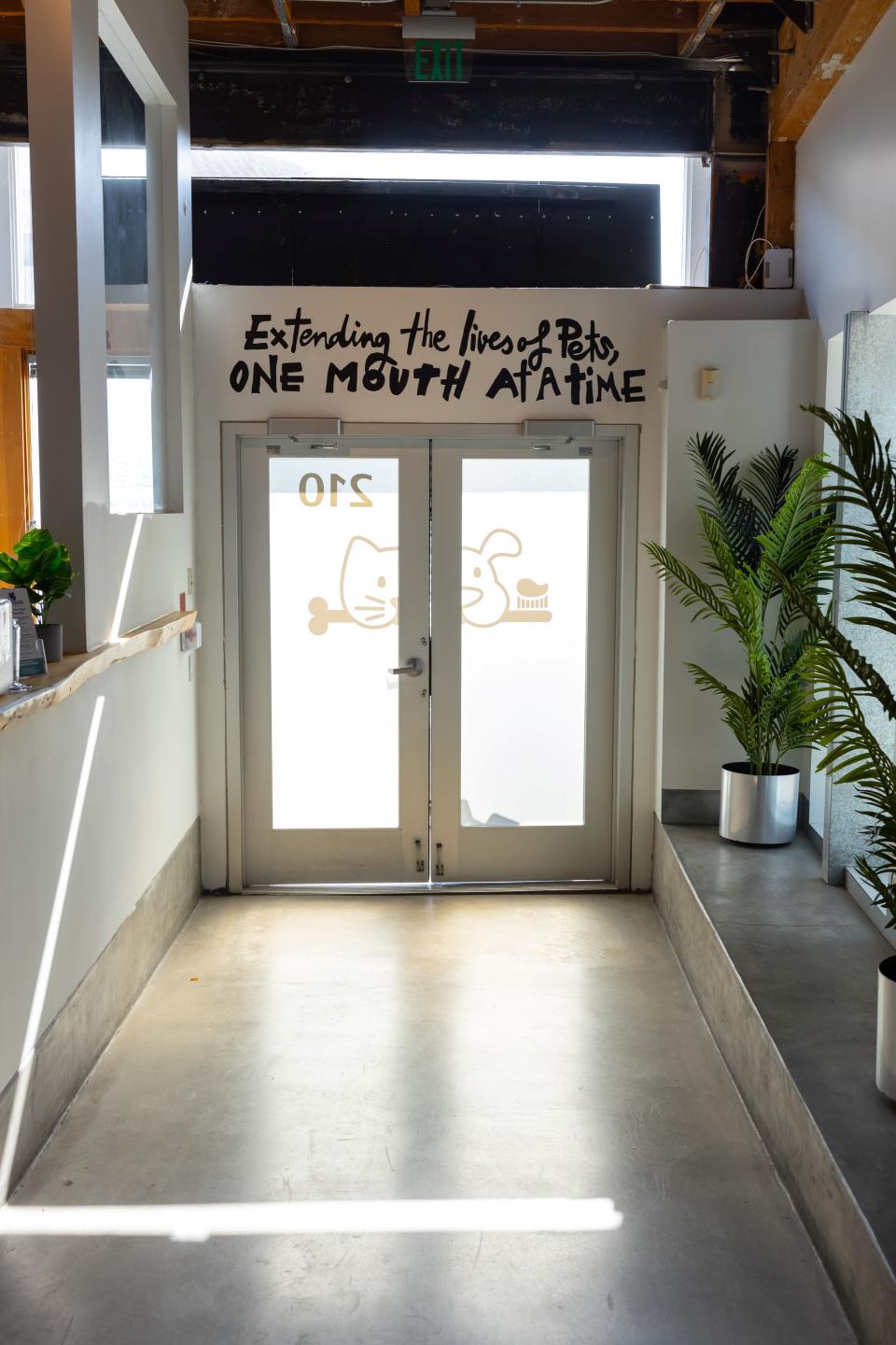 Veterinary clinic entrance doors with branded signage reading "Extending the lives of pets, one mouth at a time" in Sherman Oaks